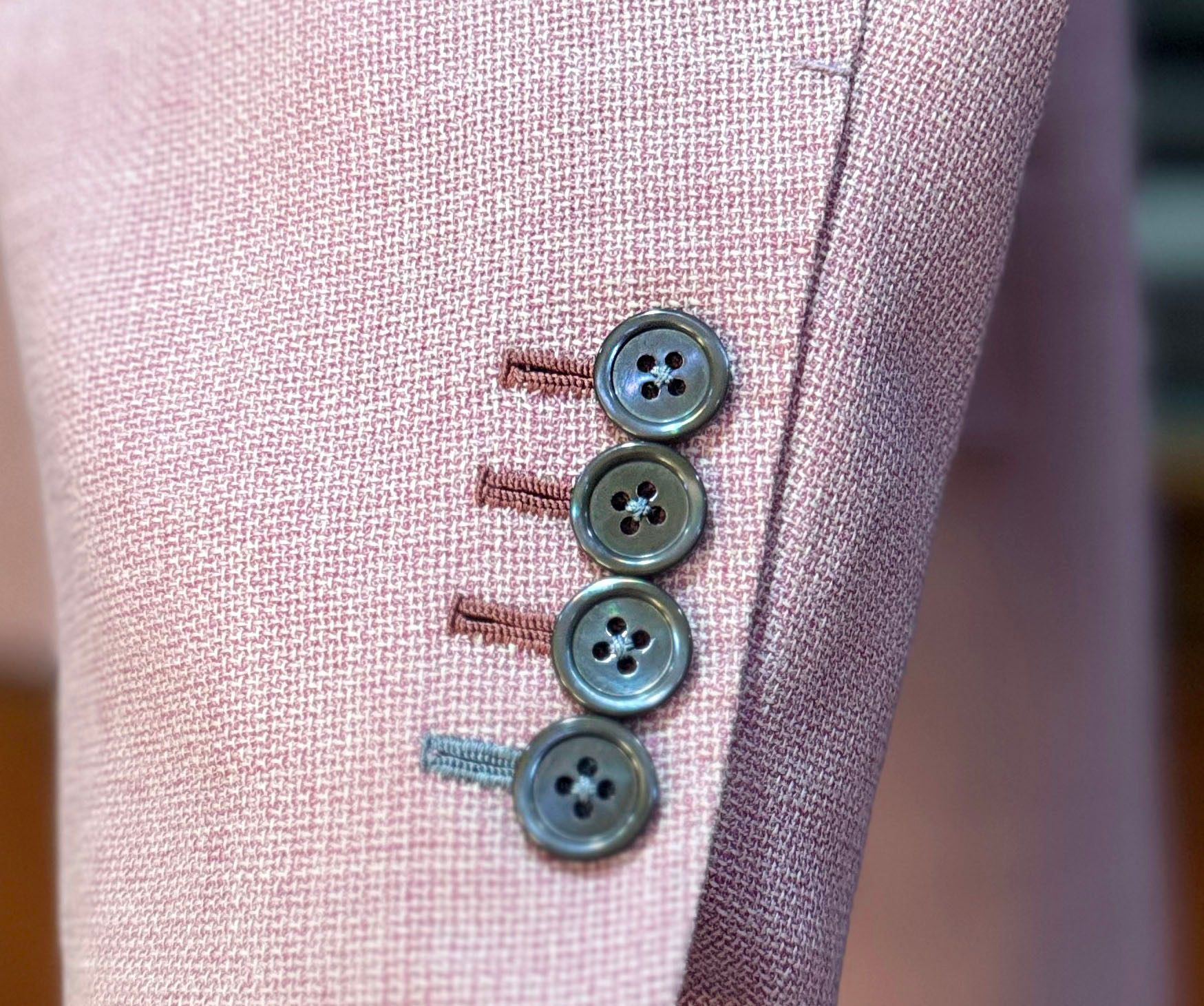 different color button hole stitching on a bespoke jacket 