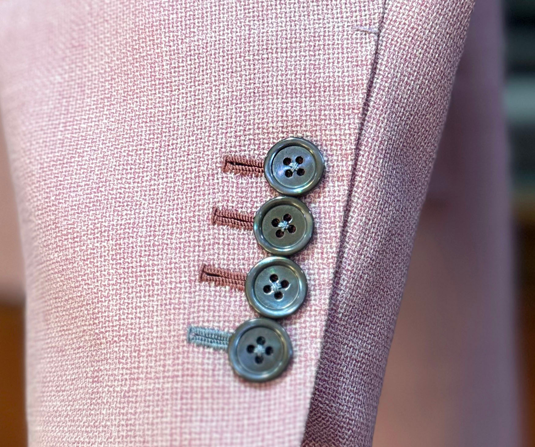 different color button hole stitching on a bespoke jacket 